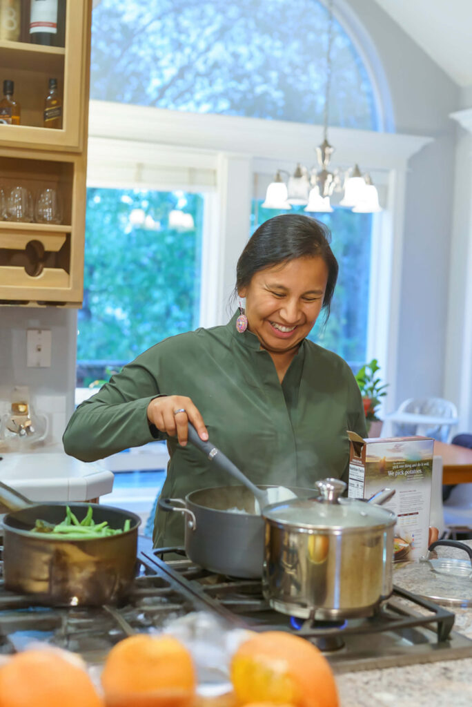 Native woman cooking on an energy efficient stove in her home