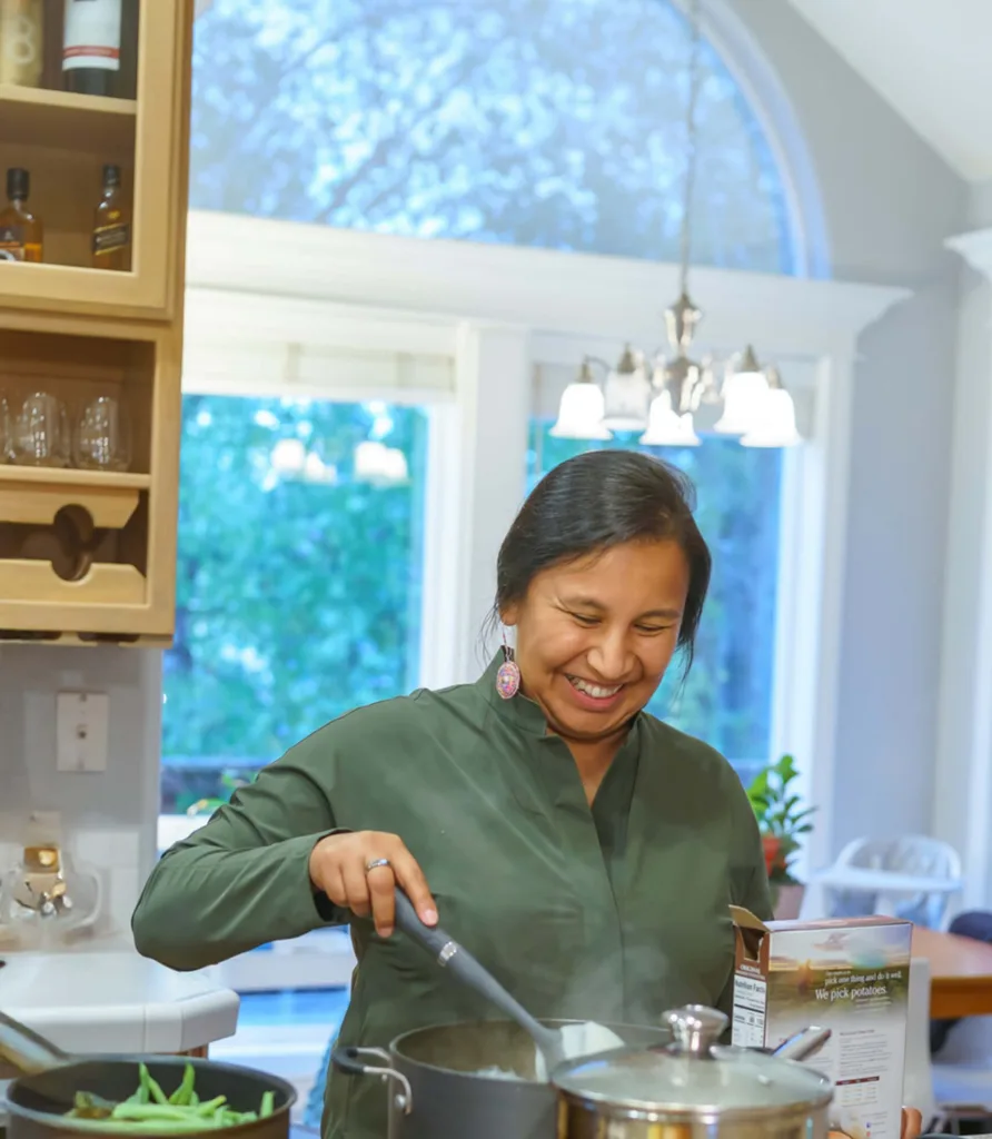 Native woman cooking on an energy efficient stove in her home